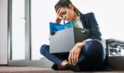 Fired young woman, employee sitting with box outside the office