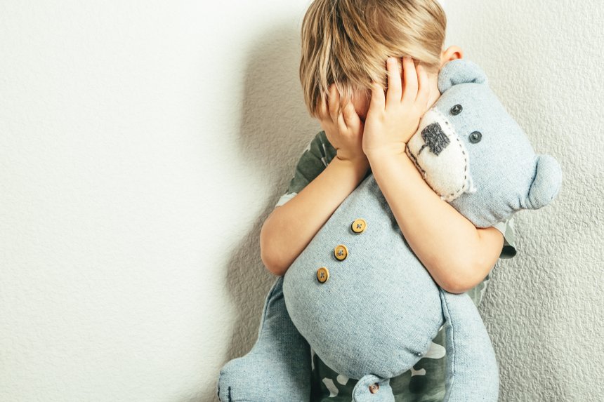 Sad depressed boy with teddy bear