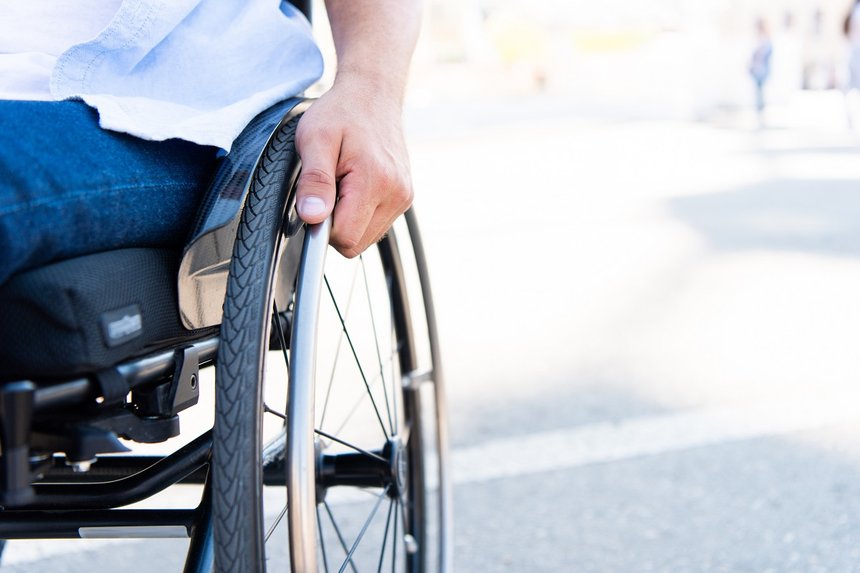 cropped image of man using wheelchair on street