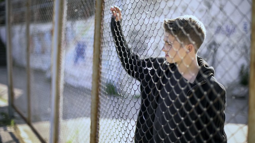 Boarding school restrictions, teen boy behind fence confinement, broken future