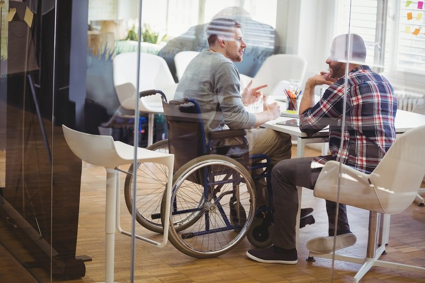 Full length of handicap businessman discussing with colleague