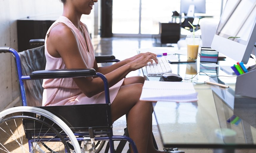 Disabled businesswoman working on computer at desk in the office