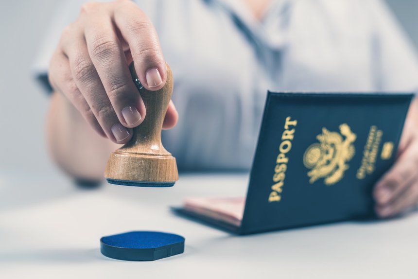 Immigration and passport control at the airport. woman border control officer puts a stamp in the US passport of american citizen. Concept