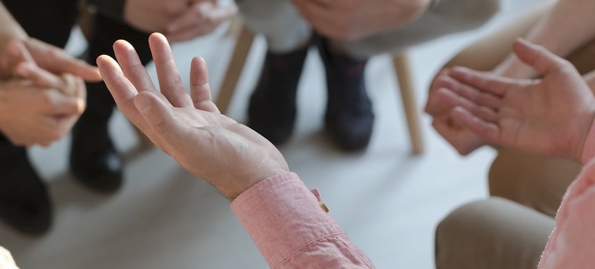 Panorama of therapist's hands while gesticulating during group therapy