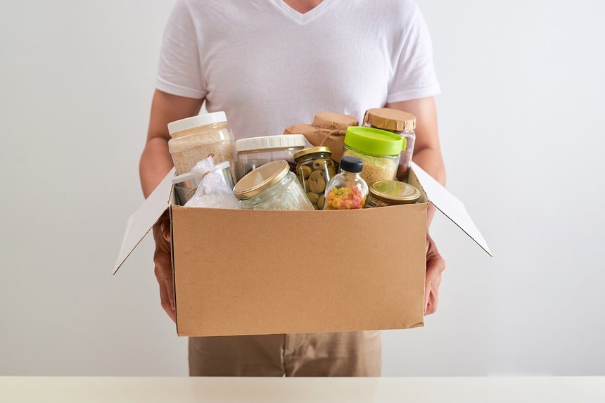 Volunteer with box of food for poor. Donation concept.