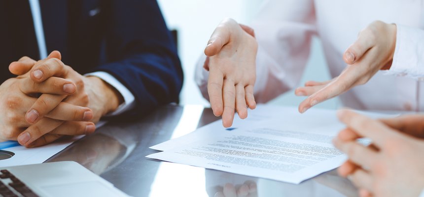 Group of business people and lawyers discussing contract papers.