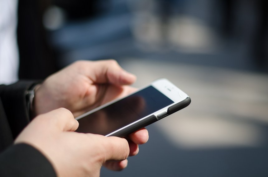 Uomo business scrive mail su cellulare