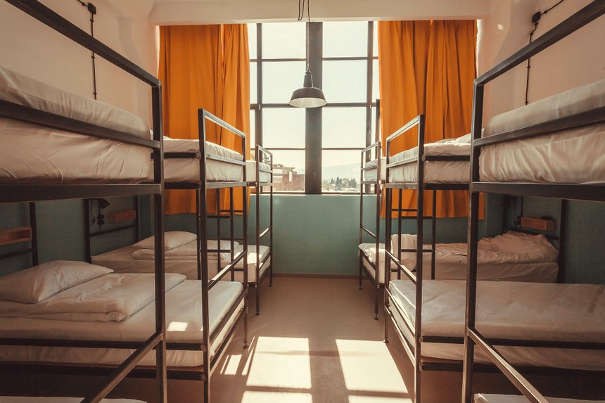 Window in bedroom of a youth hostel with clean beds for relaxing tourists and students