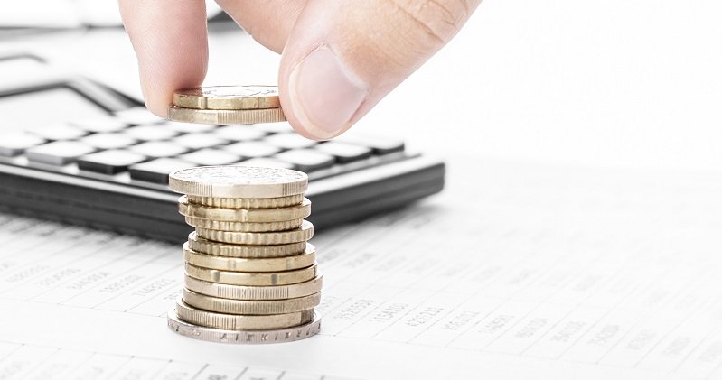 Businessman counting money and making stack of coins on financia