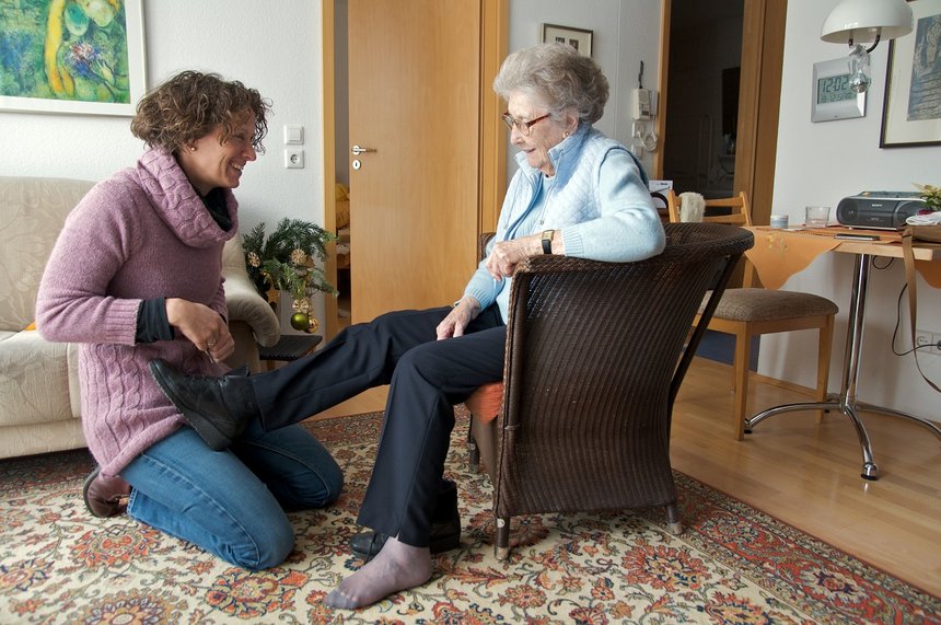 junge Frau hilft Seniorin