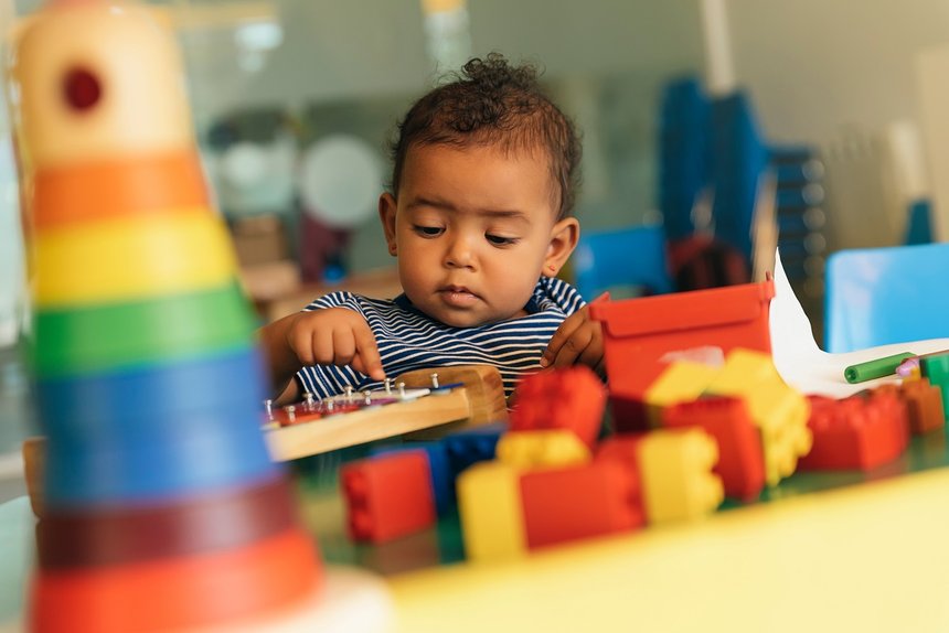 Happy baby playing with toy blocks.