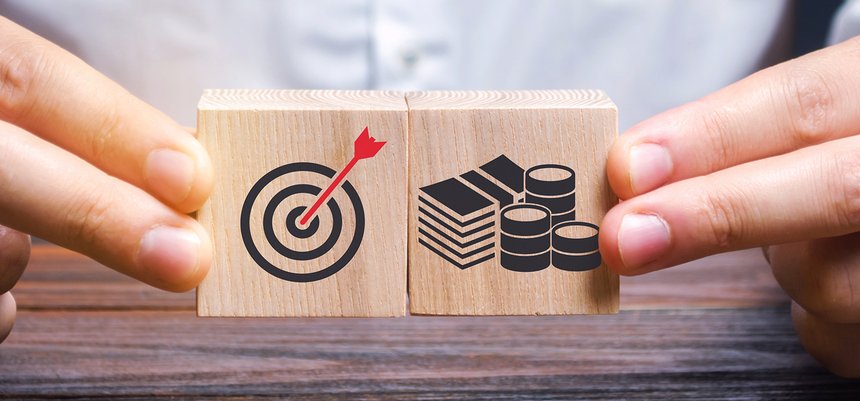 Businessman collects wooden blocks with the image of the goal an