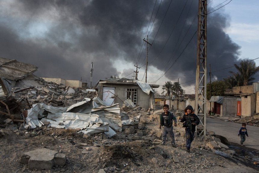 Children play in the ruins of a destroyed house.