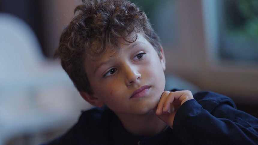 Pensive young boy portrait contemplative child face closeup