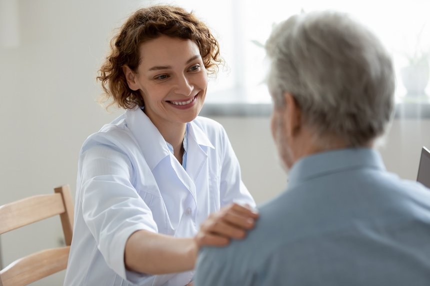 Happy young 30s physician doctor supporting elderly patient.