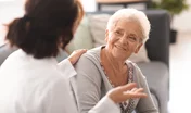 Young doctor visiting elderly woman at home
