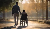 Father with son in wheelchair walking in park in autumn