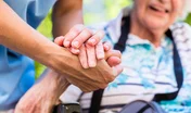 Nurse consoling senior woman holding her hand