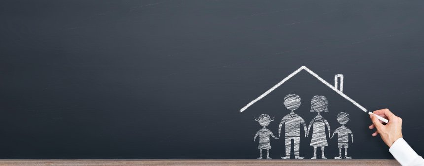 man is drawing roof on the family on chalkboard. home ownership