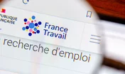 Clamart, France- 2 janvier 2024: DÃ©tail d'une page du site internet de France Travail, anciennement PÃ´le Emploi, vue avec une loupe. France Travail est l'administration franÃ§aise en charge de l'emploi