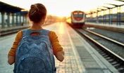 portrait of a young woman traveler with small backpack on the railway stantion